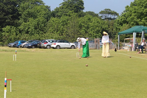 Demonstrating Edwardian Croquet, note the 2 pegs